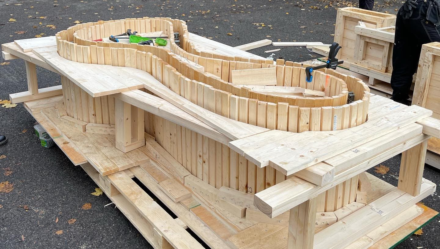 Curved timber formwork supported by wooden braces before concrete casting