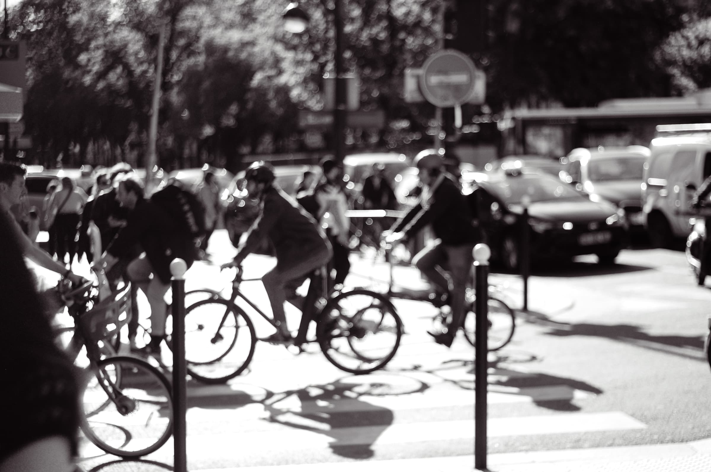 Cyclists crossing the square together, with cars behind them