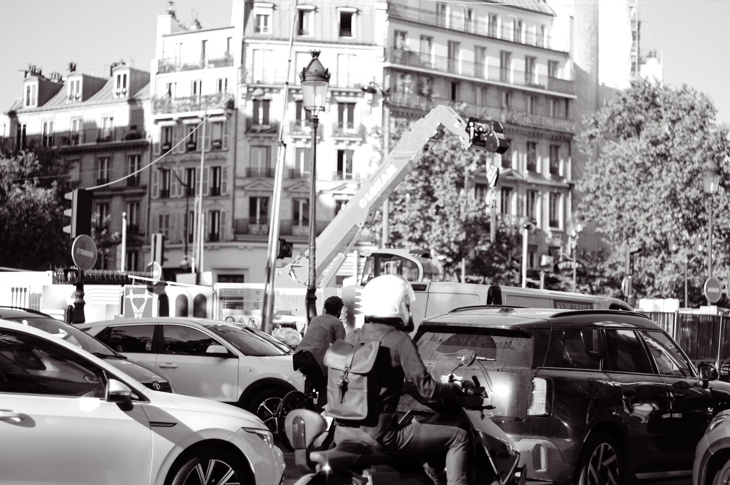 A cyclist surrounded by cars in front of the buildings of Place de Clichy
