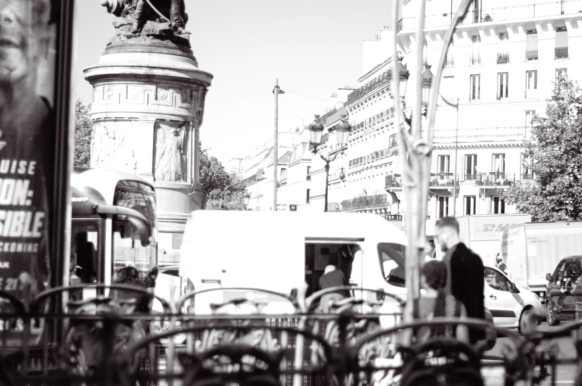 Bicycles, pedestrians, and a van crowded around the monument