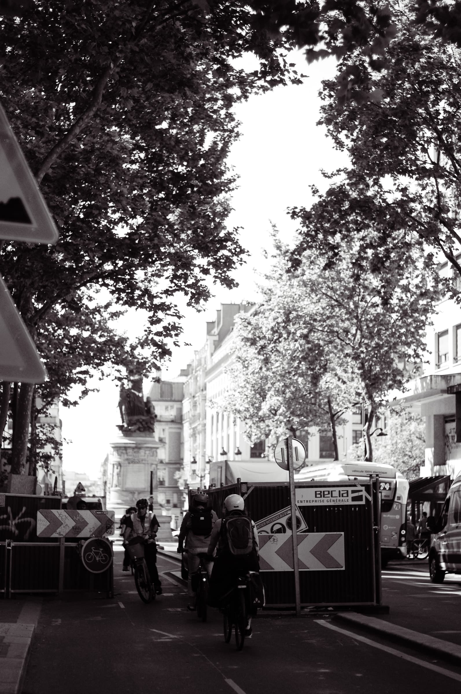 Directional barriers and site fencing beneath trees at Place de Clichy