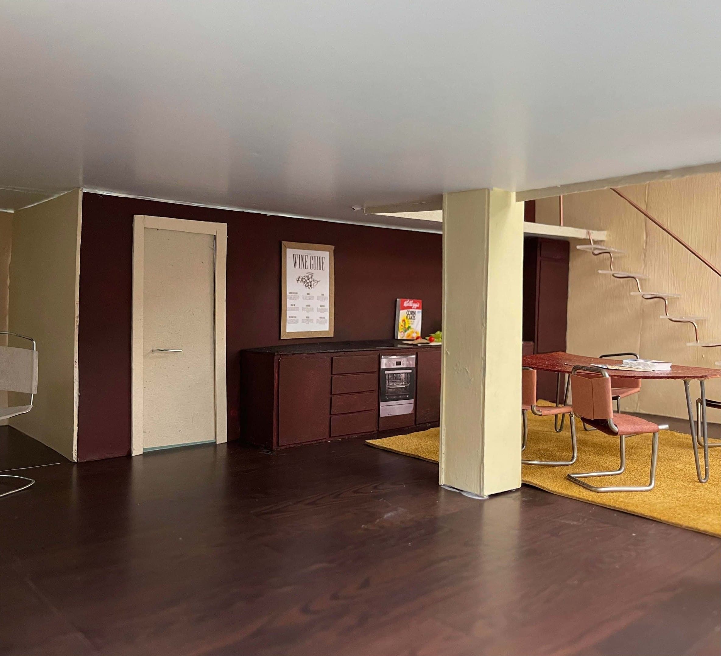 Model interior with a pale column beside the dining area and kitchen