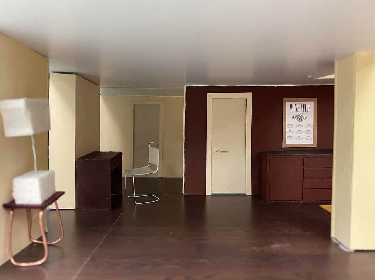 Model interior looking towards the doors and kitchen along a deep red wall